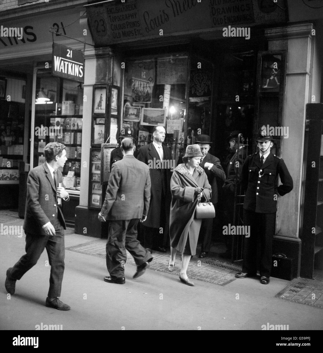 Preceded by his secretary, Miss Jean Scott Dunn, Home Office Pathologist, Dr Keith Simpson (bowler hat), leaving the antique shop of Louis Meier in Cecil Court, Charing Cross Road, London, after he had called there following the finding of the body of Mrs Elsie Batten - wife of Mark Batten, President of the Royal Society of British Sculptors. Mrs Batten, who worked at the antique shop, was found at the back of the premises with an antique dagger through her heart. Stock Photo