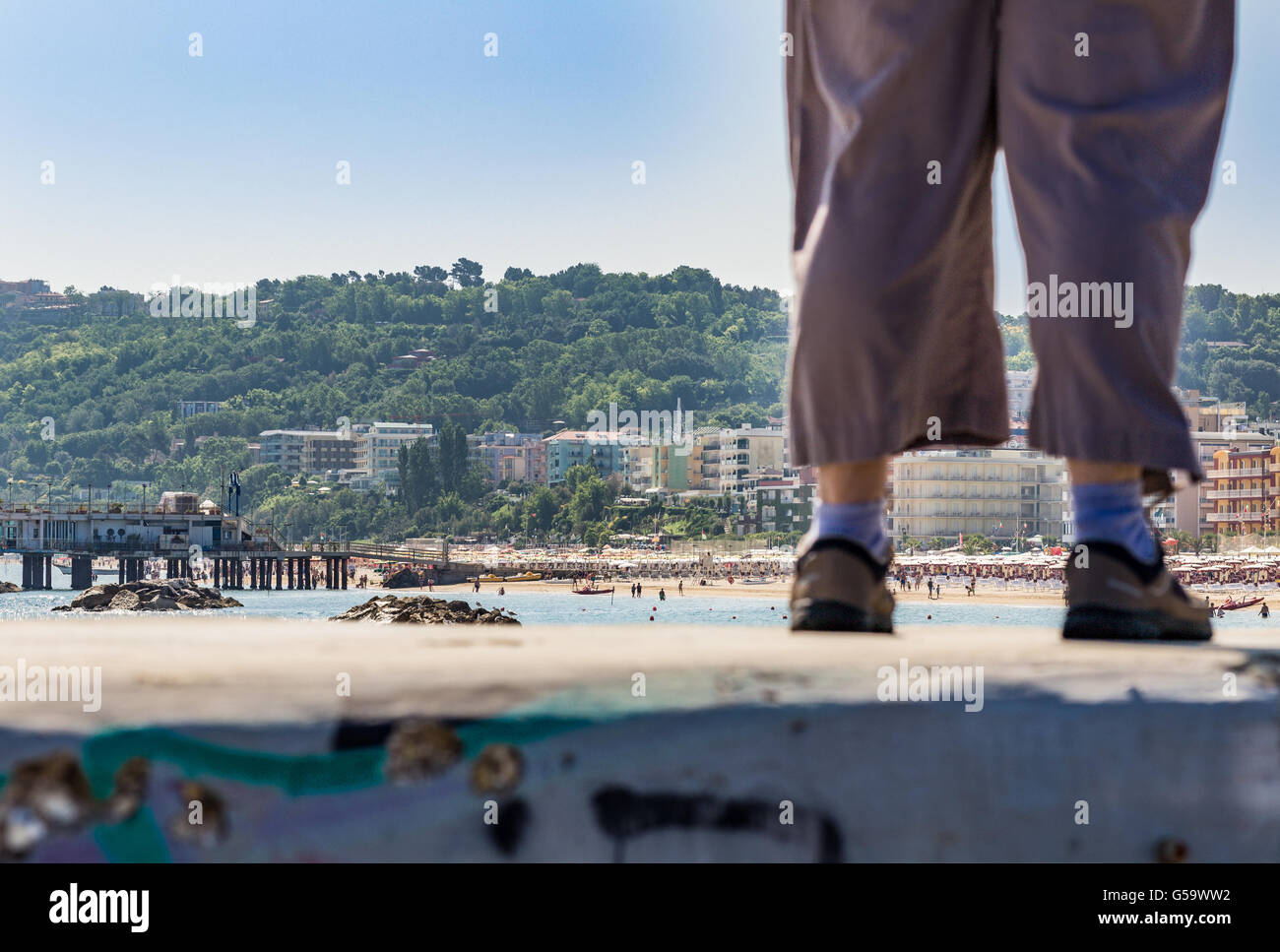 detail of legs with pants, sneakers and ankle socks on a Riviera resort background Stock Photo