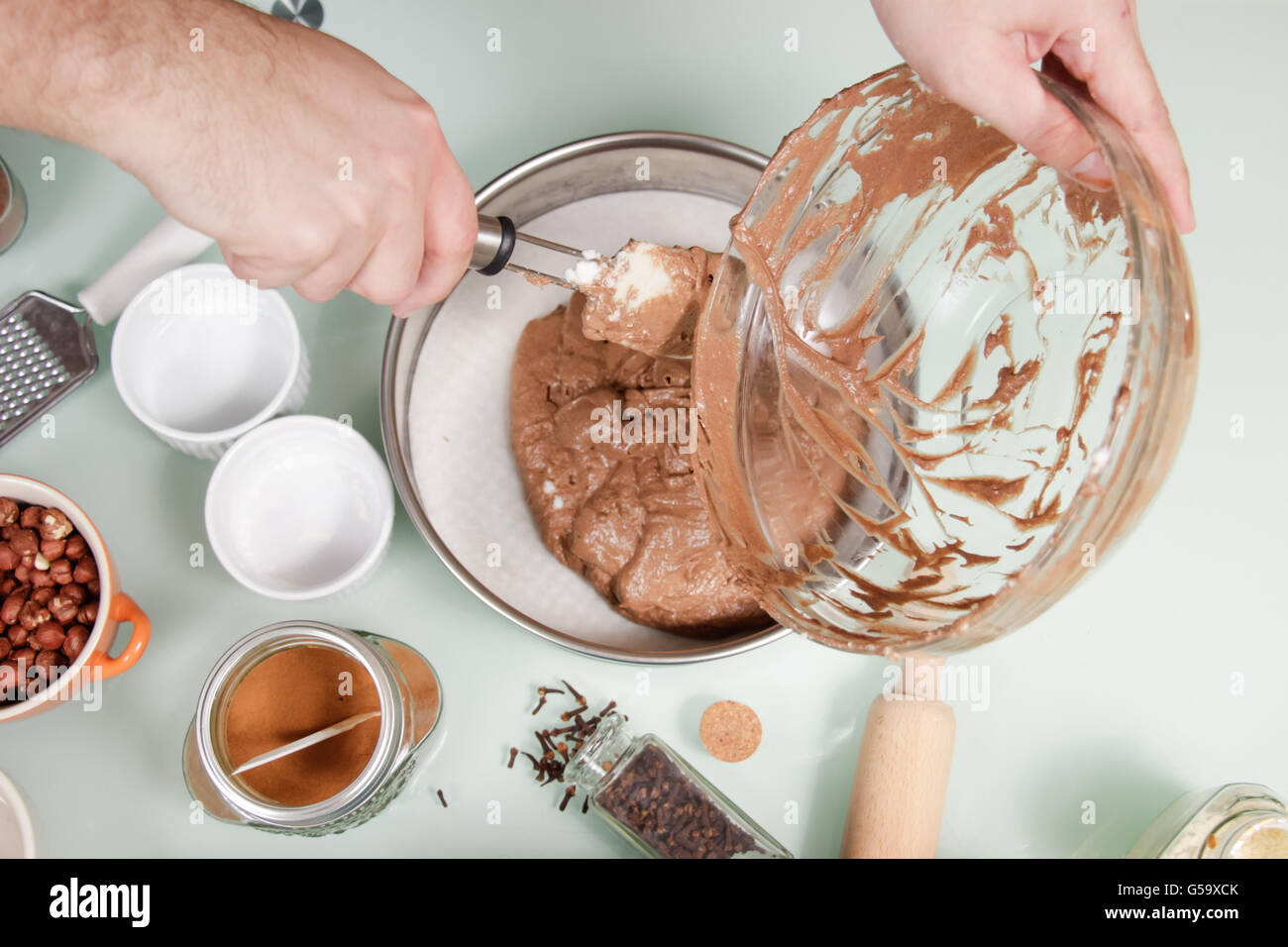 closeup hand transferring putting cake mixture cake pan Stock Photo