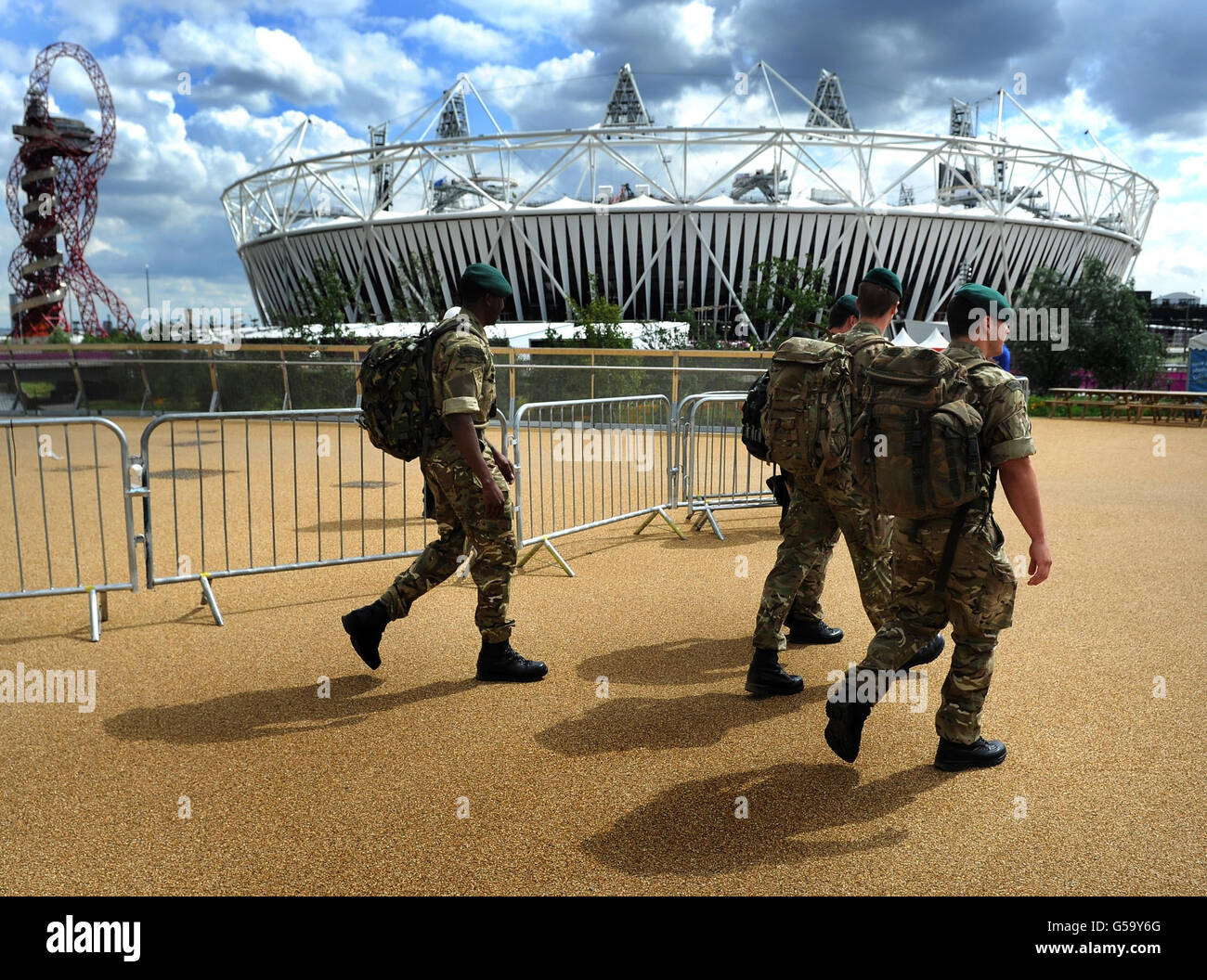 Soldiers walk past the olympic stadium in the olympic park hi-res stock ...