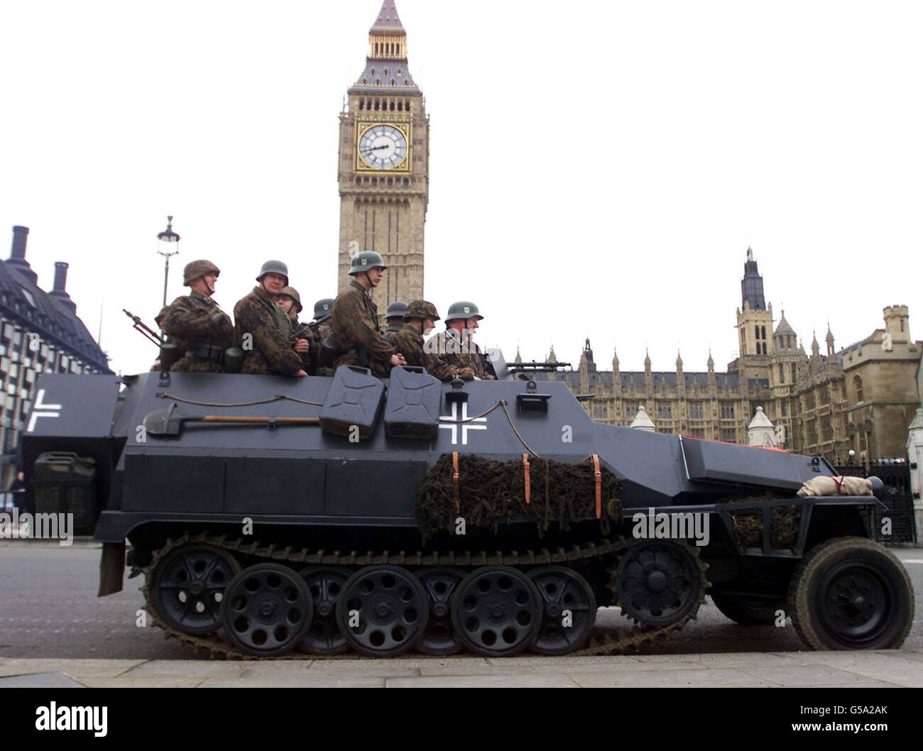 Members of the WW2 re-enactment club 'Second Battle Group' dressed in Waffen-SS uniform ride in a Sdkfz 251 half-track in Parliament Square, London. For only the 2nd time ever, the London street was closed to traffic to allow filming for a major new BBC documentary series. * Invasion, which examines Britain's history of defence will be presented by Dan Cruikshank on BBC2 in the Spring. Stock Photo