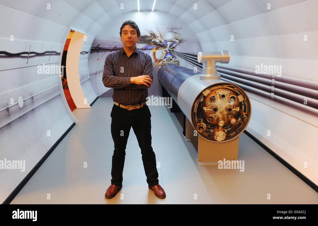 University College London Professor John Butterworth, a scientist on the Atlas experiment, whose findings are being announced today, stands with a model of the Large Hadron Collider in London. Stock Photo