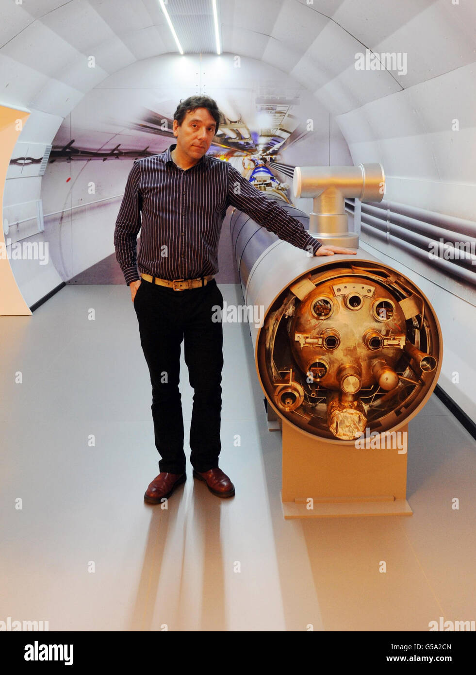 University College London Professor John Butterworth, a scientist on the Atlas experiment, whose findings are being announced today, stands with a model of the Large Hadron Collider in London. Stock Photo