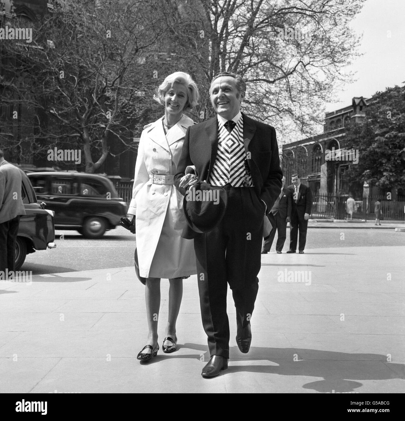 Labour MP for Pontypool Leo Abse, who is conducting a one-man campaign to brighten up the House of Commons sartorially, arriving with his wife at the Houses of Parliament, London, on Budget Day 1966. Stock Photo