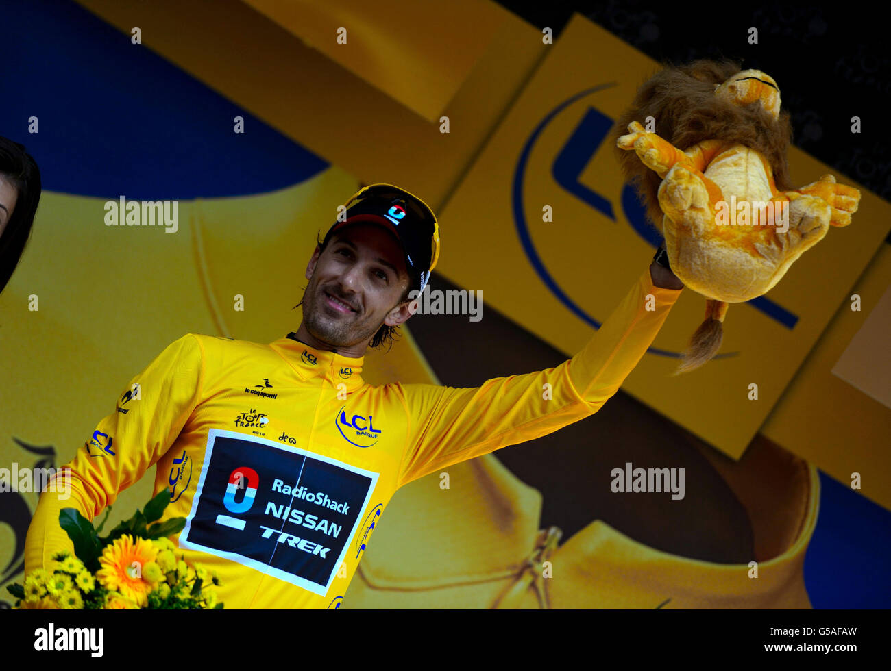 Fabian Cancellara stands on the podium with his trophy and collects the yellow leader's jersey after winning the Prologue Stage of the 2012 Tour de France in Liege, Belgium. Stock Photo