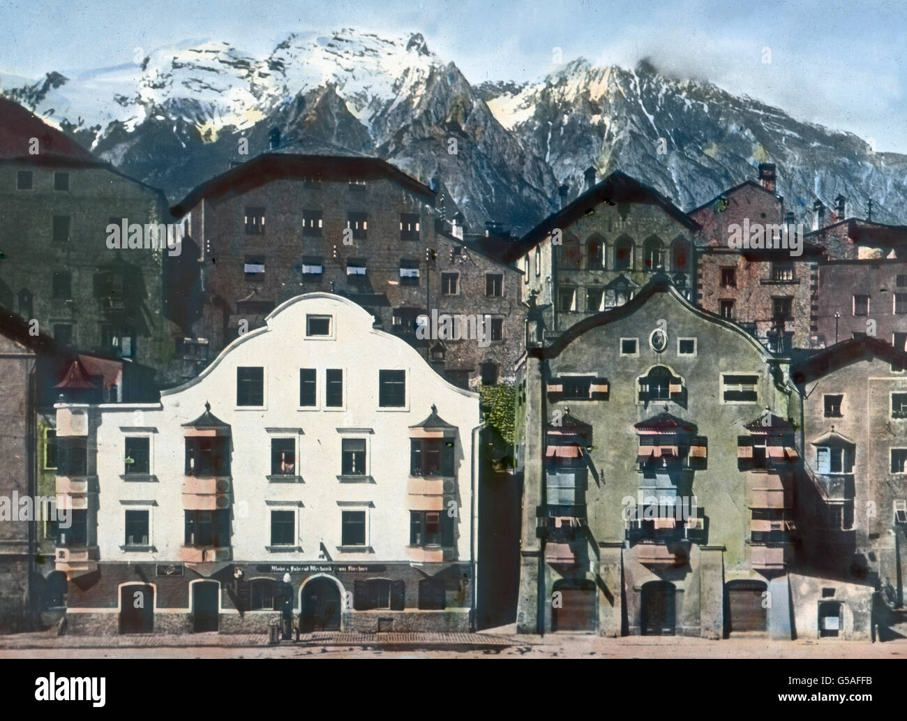 Inmitten der Tuxer Schieferalpen liegt unweit Innsbruck die alte Stadt Hall in Tirol, ein bekanntes Solbad an der Bahn Kufstein-Innsbruck. Das Wort Hall bedeutet übrigens Salz. Wo das Wort selbständig oder in einer Verbindung angewandt wird, ist sicher ein Salzvorkommen nachweisbar. Hall in Tirol war durch seine ergiebige Saline im Mittelalter ein behäbig-wohlhabender Ort, wovon noch diese breit hingelagerten Giebelhäuser künden. Auch heute macht die Stadt, von der aus viele herrliche Berggebiete erschlossen werden, einen anheimelnd freundlichen Eindruck. Austria, 1910s, 1920s, 20th century, a Stock Photo