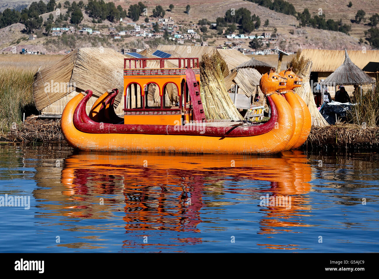 Orange totora reed boat and totora reed island, Uros Islands, Lake Titicaca, Puno, Peru Stock Photo