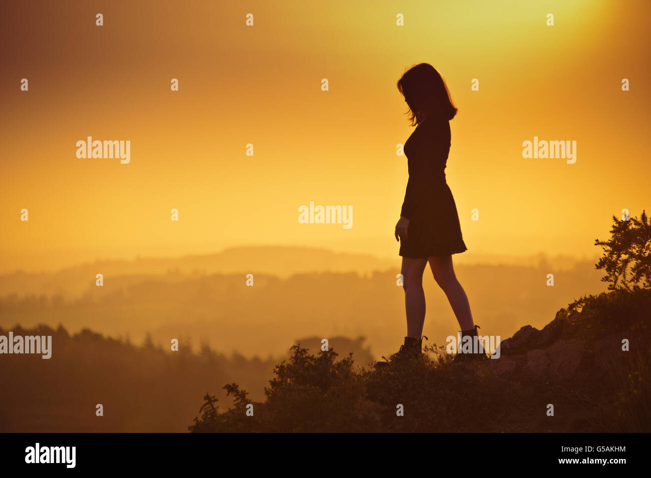 Silhouette of a young woman walking at sunset Stock Photo - Alamy