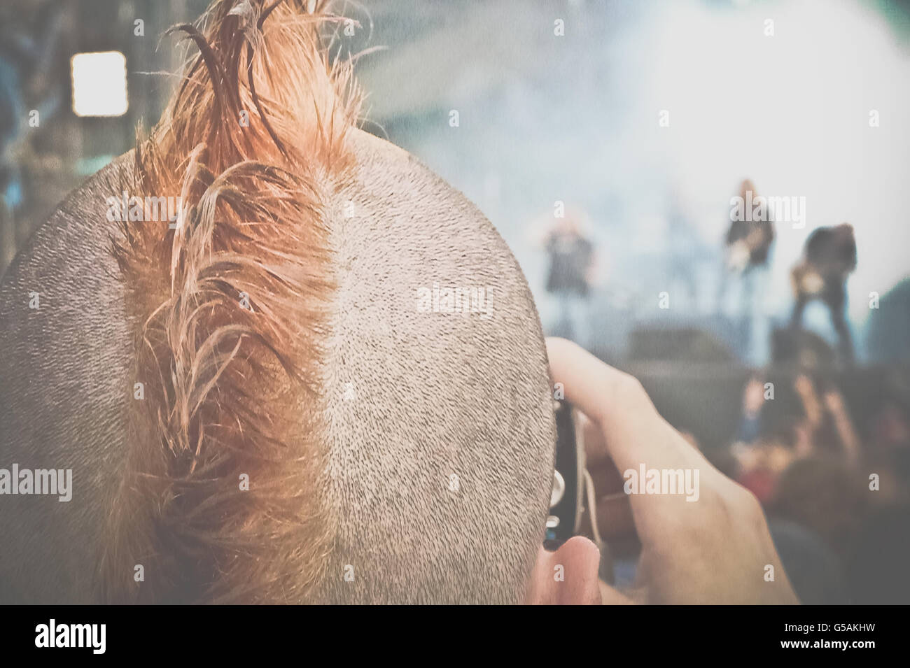 A punk spectator taking a picture of Lynyrd Skynyrd playing live concert at Hellfest music festival in Clisson, France Stock Photo