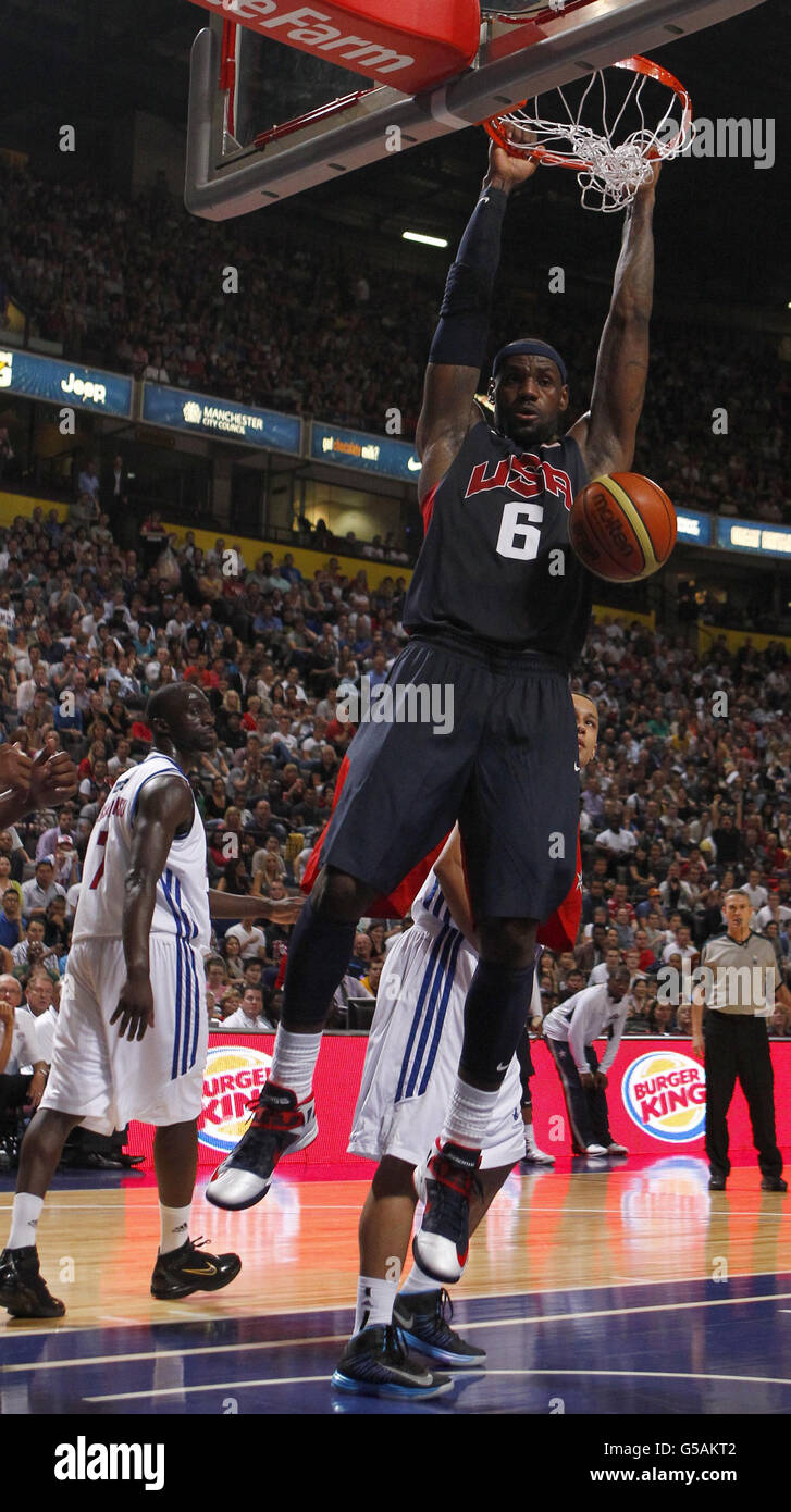 LeBron James of the USA hangs from the hoop after scoring during an Olympic  Warm Up match at the Manchester Arena, Manchester Stock Photo - Alamy