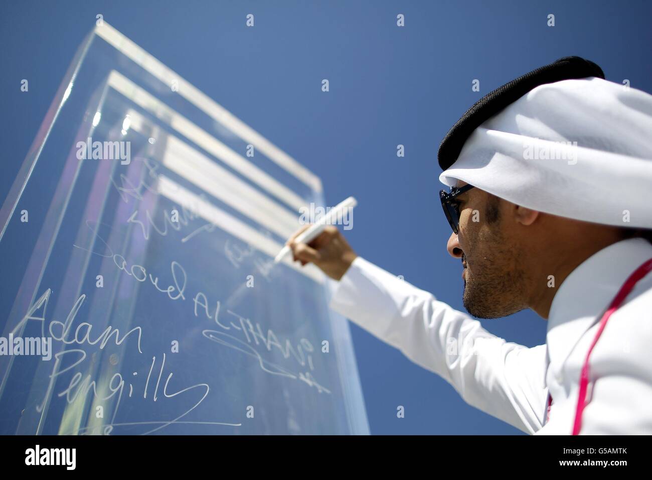 Qatari Full Names A member of the Qatari team signs his name on the Peace Wall inside the ...