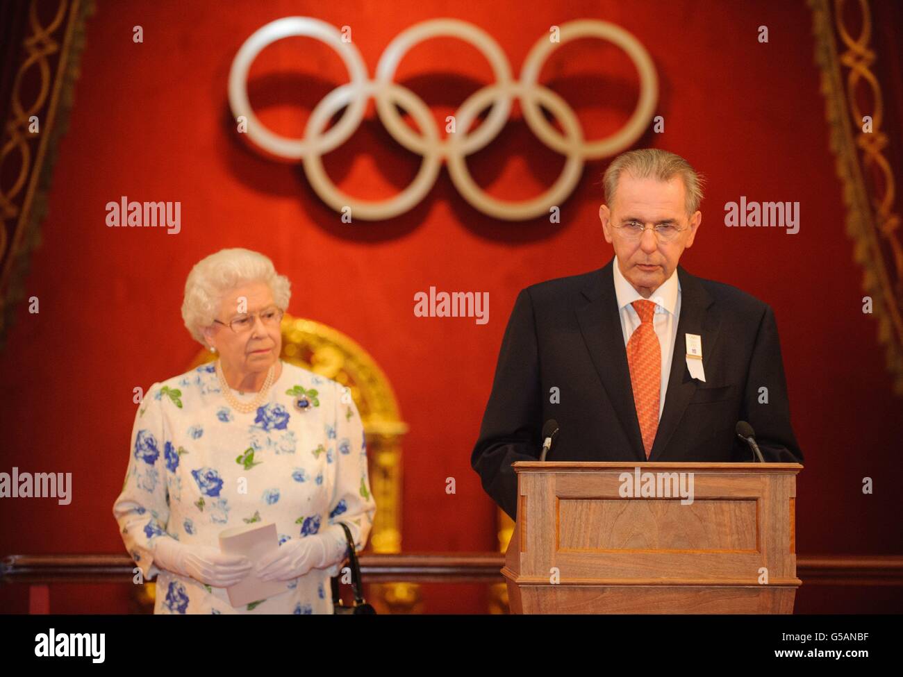 Queen Elizabeth II listens as President of the International Olympic Committee Count, Jacques Rogge, speaks at a reception for members of the International Olympic Committee, at Buckingham Palace, in central London. Stock Photo
