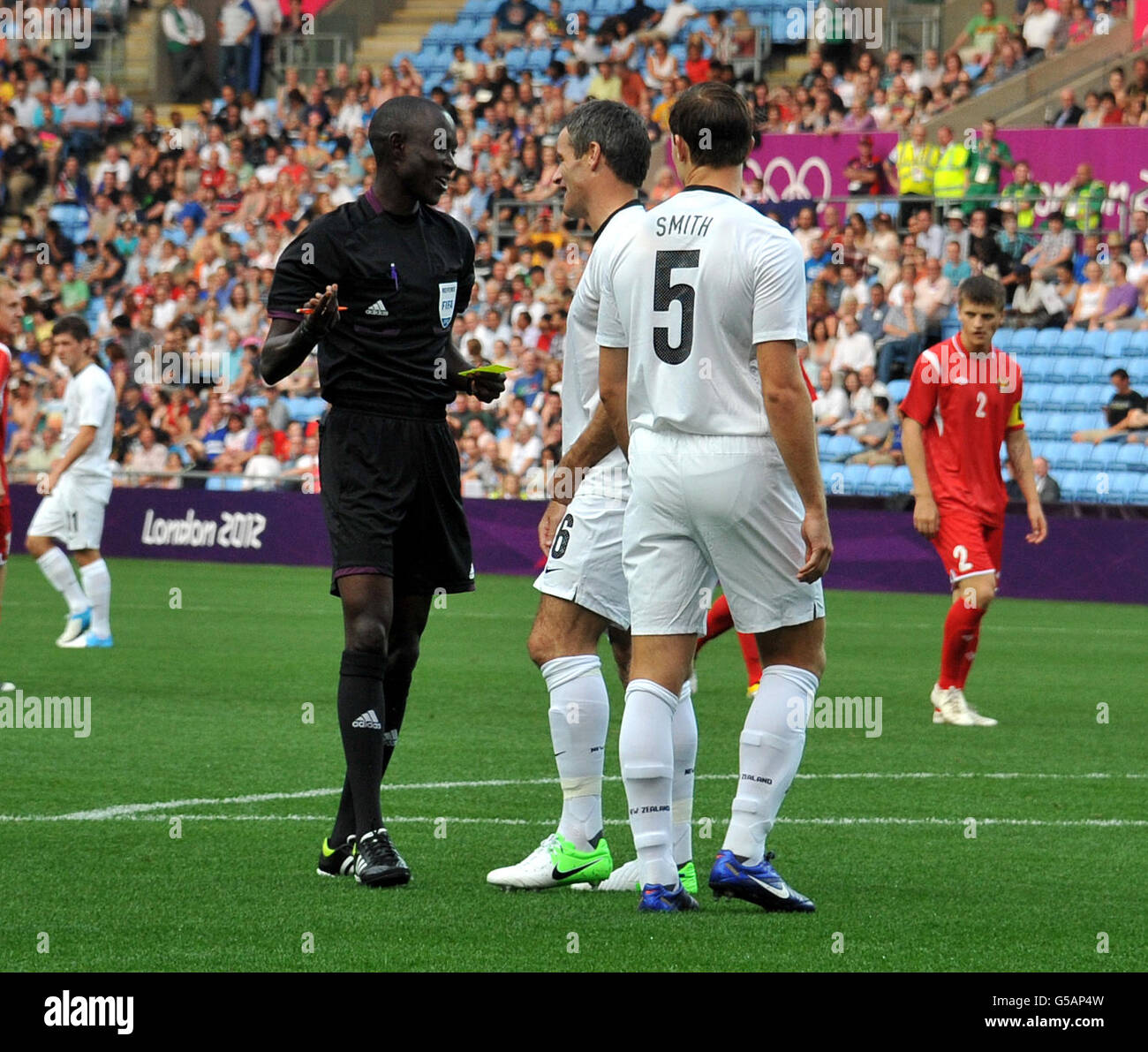 New Zealand's Tommy Smith is booked by referee Bakary Gassama during
