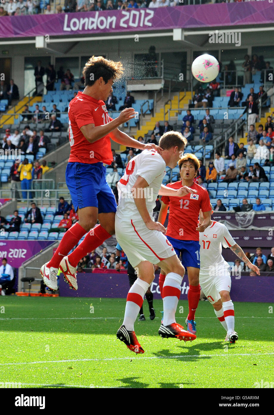 South Korea's Chuyoung Park out jumps Switzerland's Fabian Frei during the Olympic Soccer match at the City of Coventry Stadium. Coventry. Stock Photo