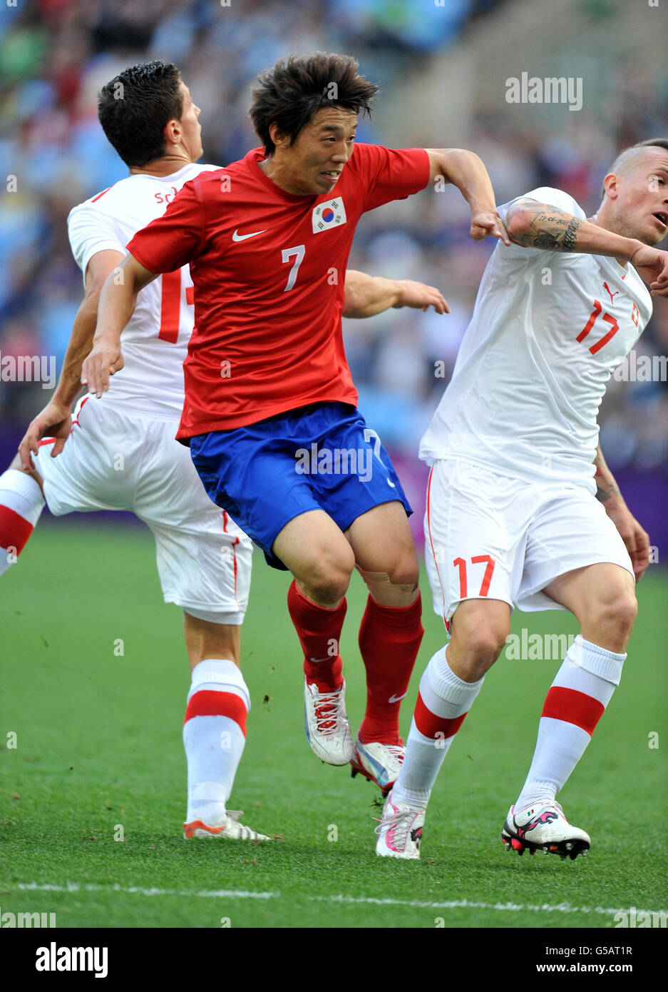 Korea's Bokyung Kim Is sandwiched between Switzerland's Fabian Schaer and Michel Morganella during the Olympic Soccer match at the City of Coventry Stadium. Coventry. Stock Photo