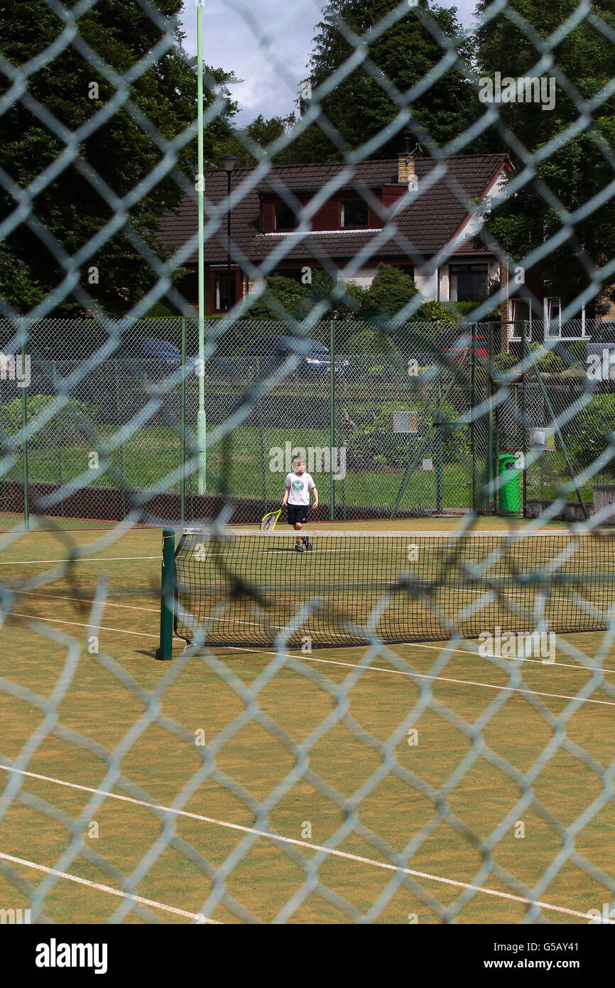 A Dunblane Tennis Club member (name unknown) plays tennis during the match, as the streets in Andy Murray's hometown are almost deserted as tennis fans gather to watch his bid to become the first British man to win Wimbledon in 76 years. Stock Photo