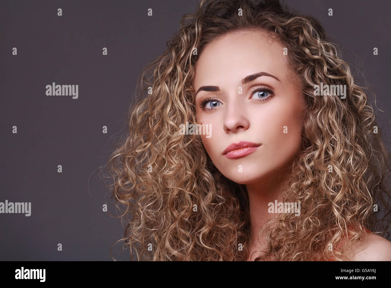 Portrait of woman with curly hair Stock Photo - Alamy
