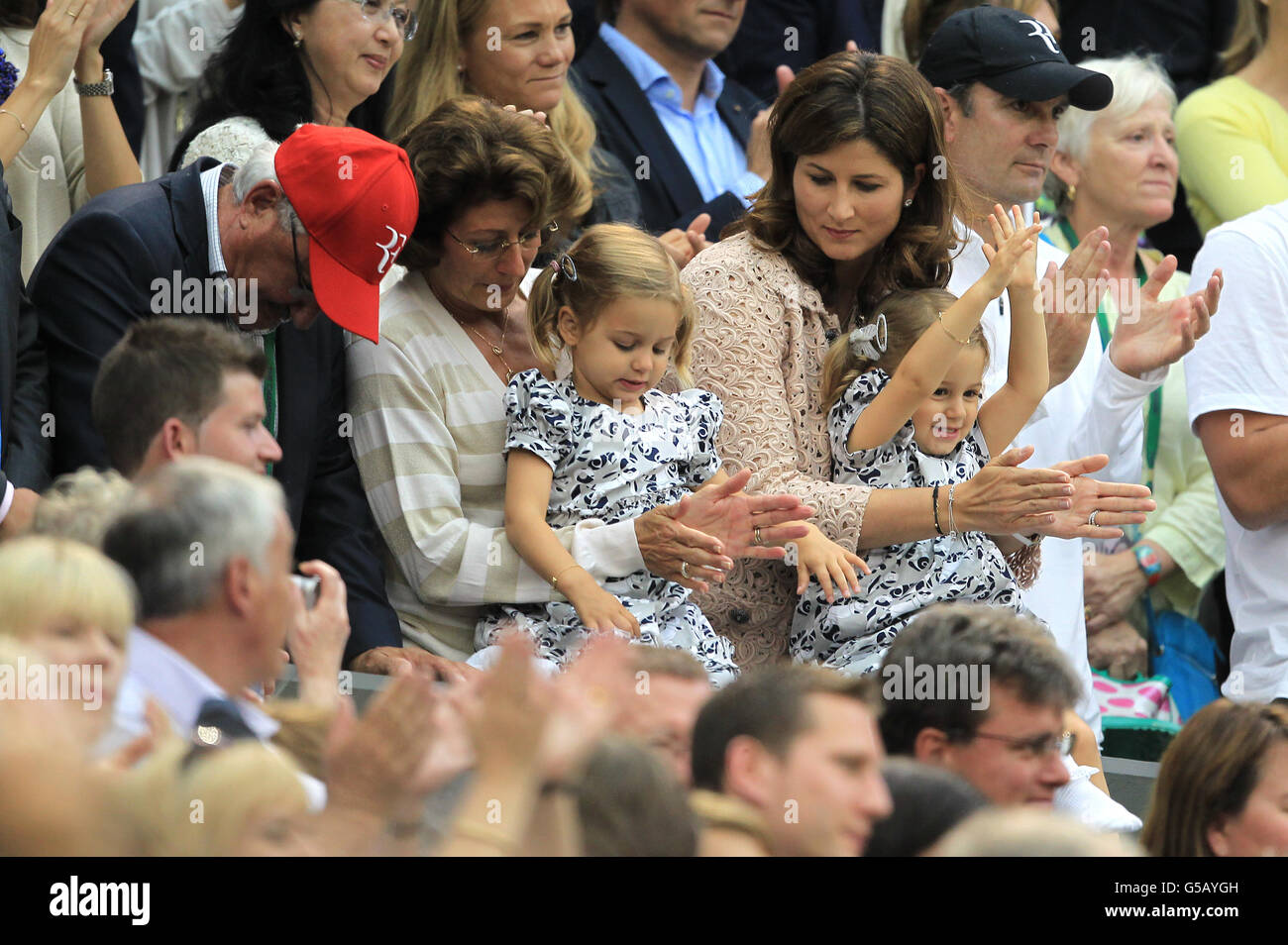Switzerland's Roger Federer's wife Mirka Vavrinec with daughters Myla and Charlene during day thirteen of the 2012 Wimbledon Championships at the All England Lawn Tennis Club, Wimbledon. Stock Photo