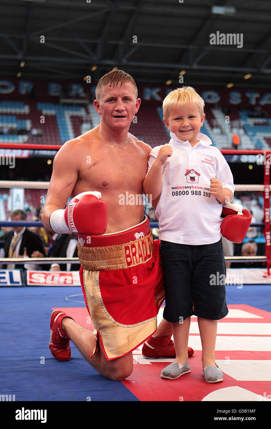 Bradley Saunders celebrates after beating Kevin McCauley with his son Leighton, aged 5, in a light-welterweight bout at Upton Park, London. Stock Photo