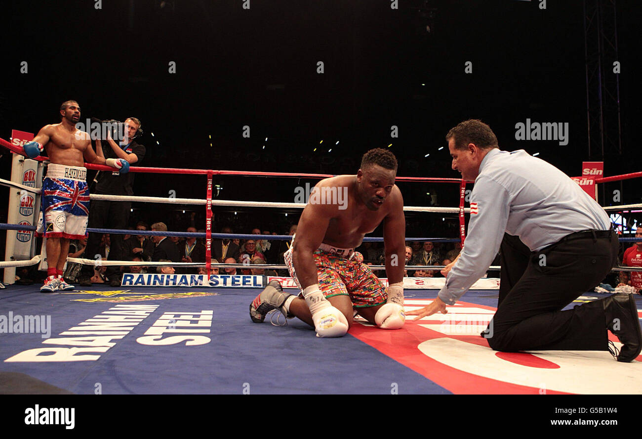 Dereck Chisora tries to recover after being knocked down by David Haye (left) for the first time in their WBA and WBO International Heavyweight Championship bout at Upton Park, London. Stock Photo