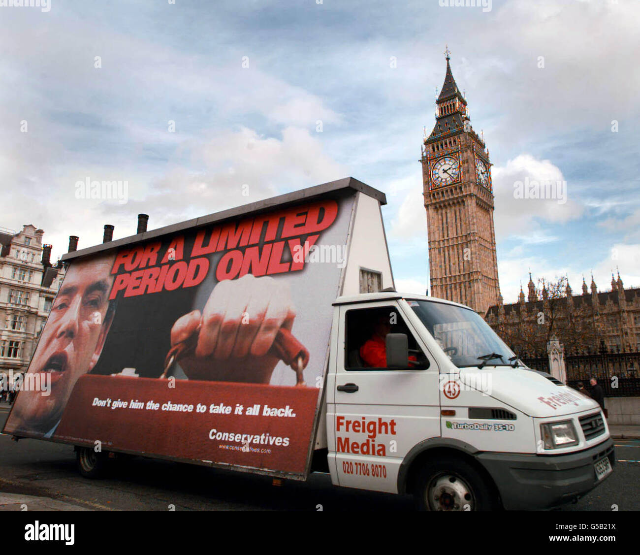 A billboard carrying a Conservative Party campaign poster targetted at Chancellor Gordon Brown's taxation policy passes the House of Commons in London, on annual budget day. Mr Brown promised Cabinet colleagues a cautious Budget * ... with tax cuts carefully targeted at Labour's priority areas'. Stock Photo