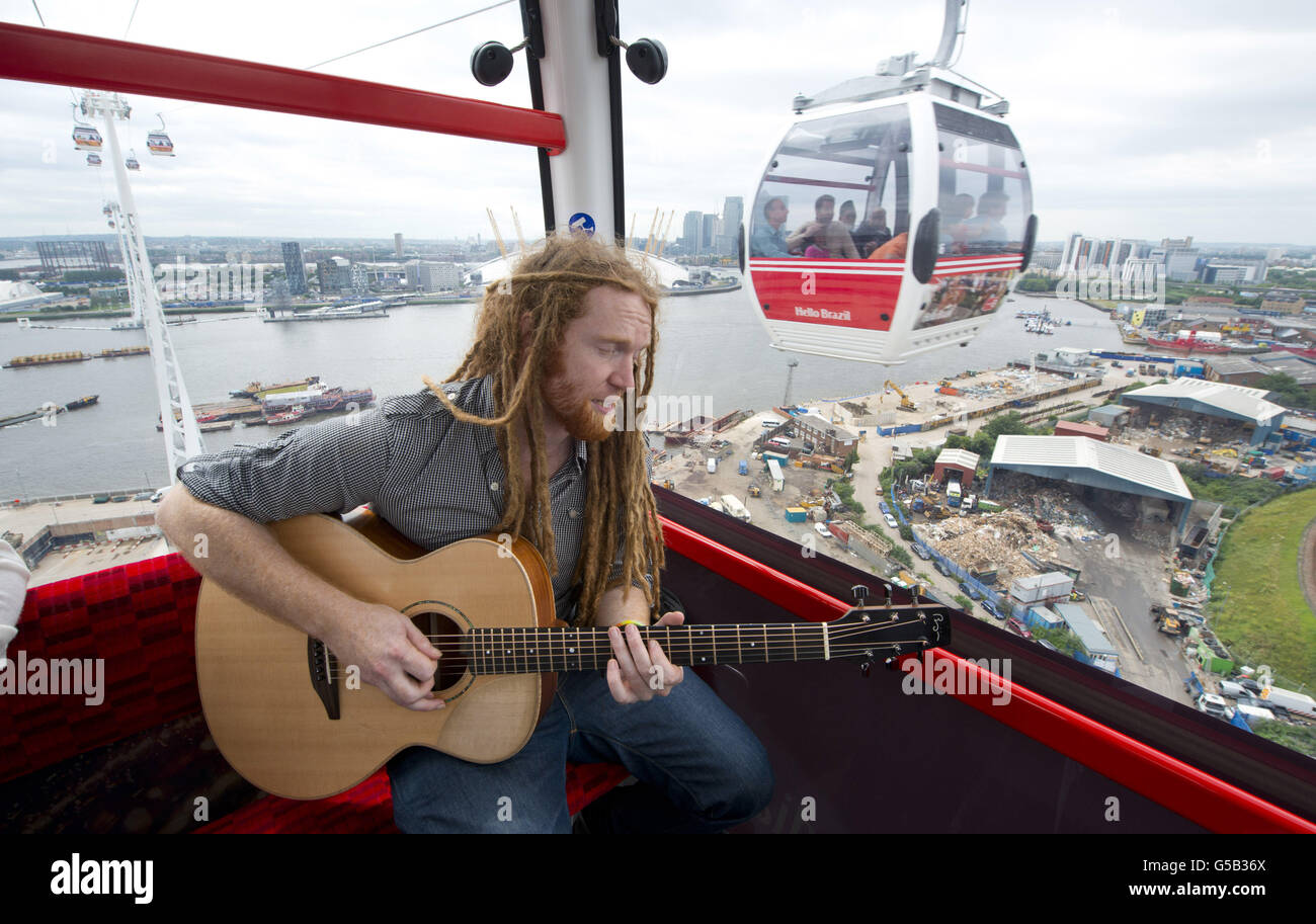 Newton Faulkner performs an exclusive gig for competition winners in one of the Olympic Emirates Air Cable Cars, which cross the river Thames in east London. Stock Photo