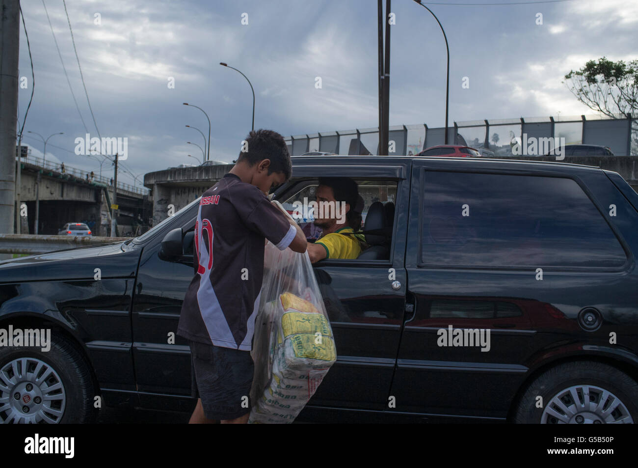 Child labor, street vendor works during rush hour traffic jam at Linha