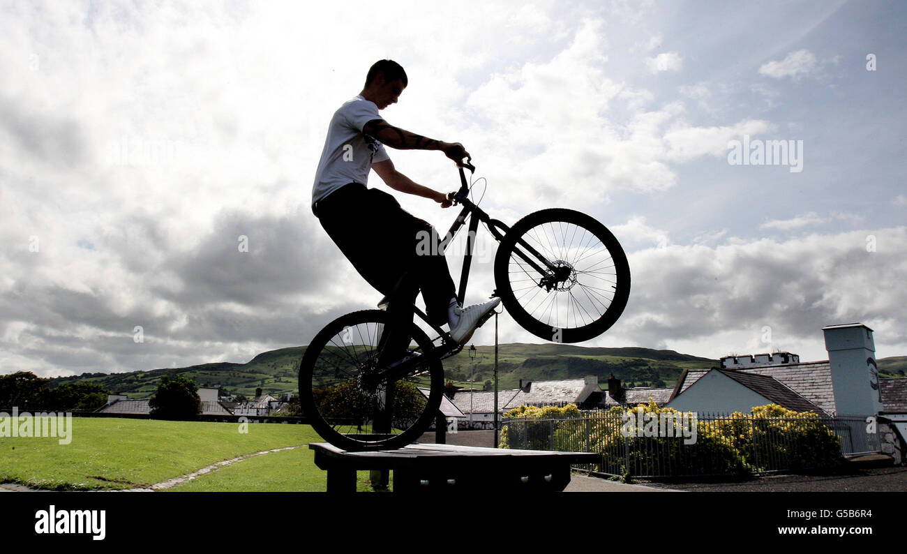 Lawrence McKinley, from Carnlough Co Antrim, practices his balancing skills  on his bike on top of a picnic table in the Co Antrim village, as the warm  weather spreads across the province