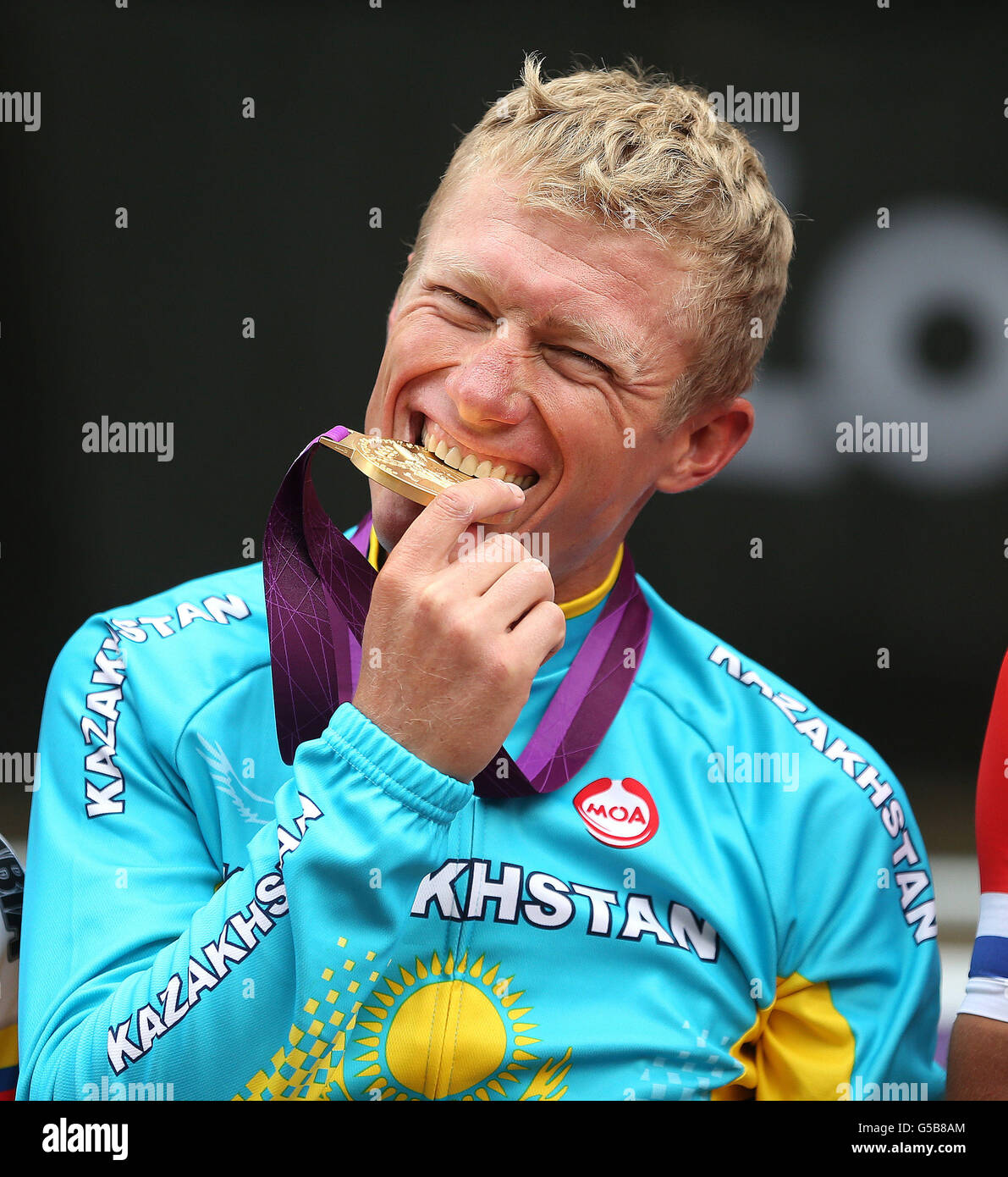 Kazakstan's Alexandr Vinokurov bites his gold medal after winning the mens Road Race Stock Photo