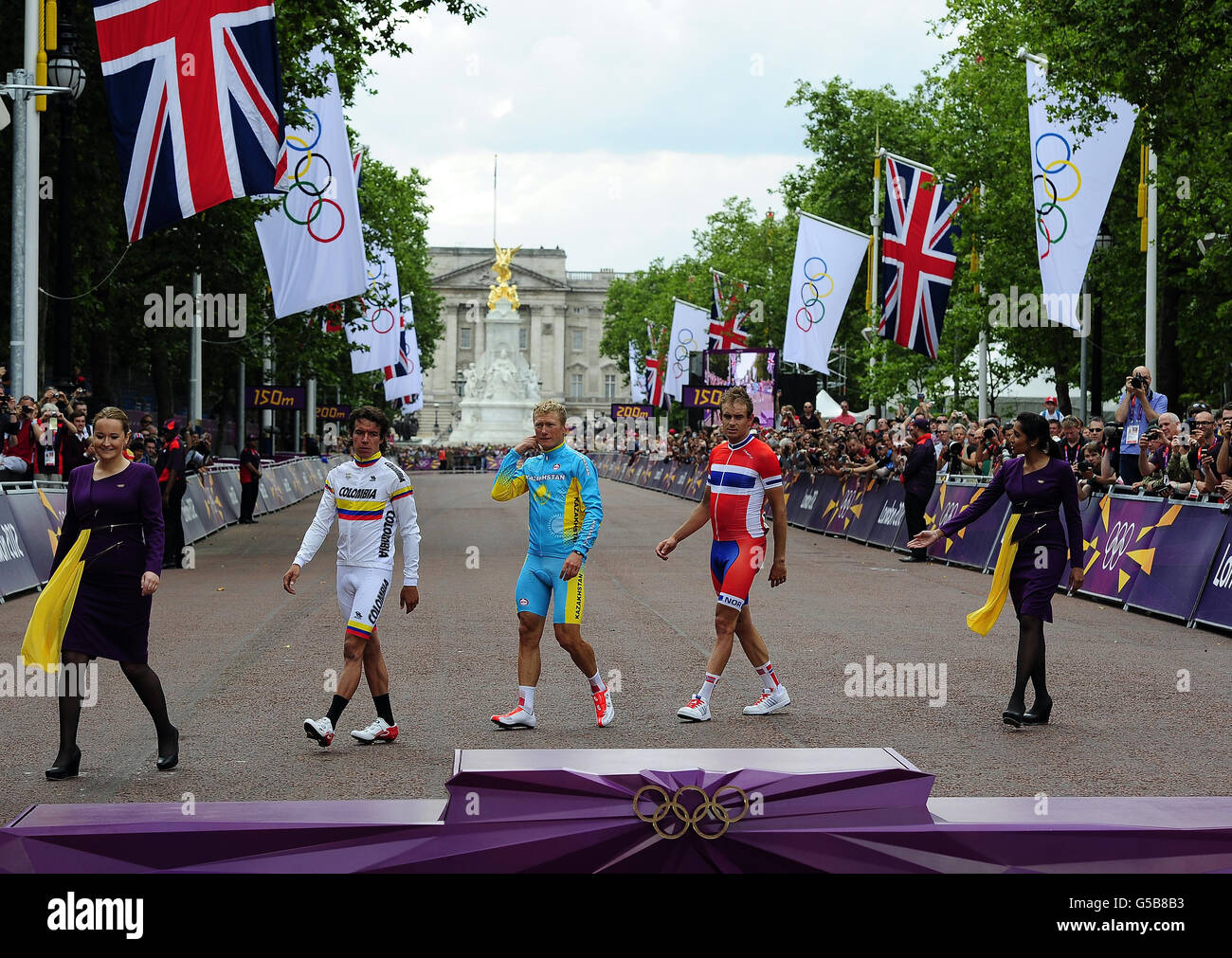 Kazakhstan's Alexandr Vinolurov walks out to collect his Gold medal alongside second placed Rigoberto Uran Uran and third placed Norway's Alexander Kristoff following the Men's Road Race in the Mall, London. Stock Photo