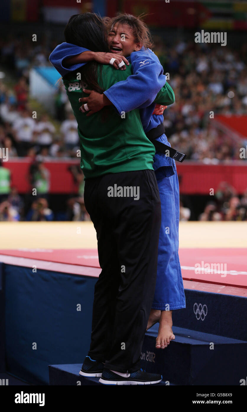 Brazil's Sarah Menezes celebrates her win with her coach after gaining a submission victory in Gold medal contest against Romania's Alina Dumitru at the ExCel Arena, London. Stock Photo