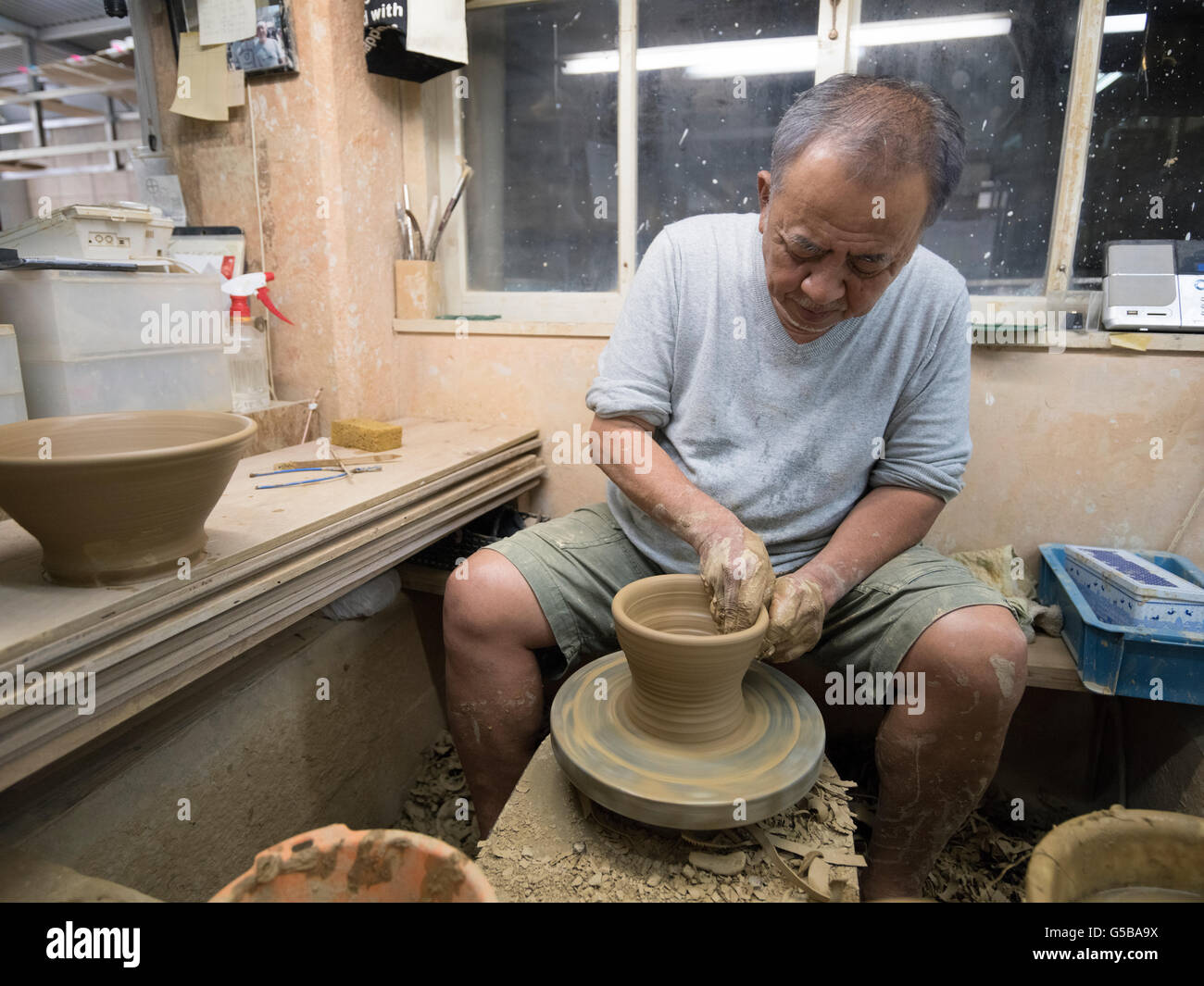 Tsuboya Tadashi Takaesu at the wheel in Tsuboya Pottery District , Naha City ...