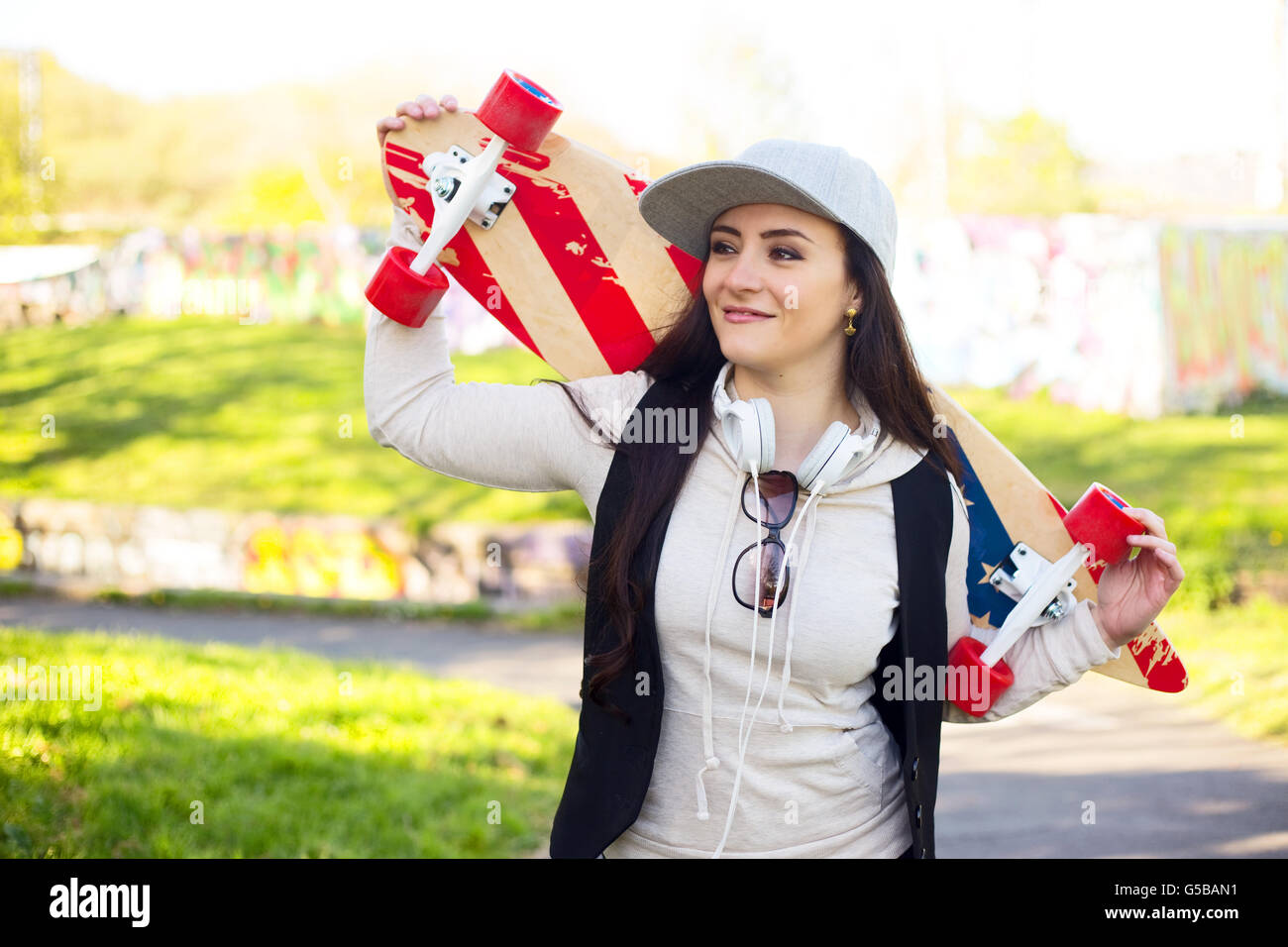 young woman in the park holding her skateboard Stock Photo