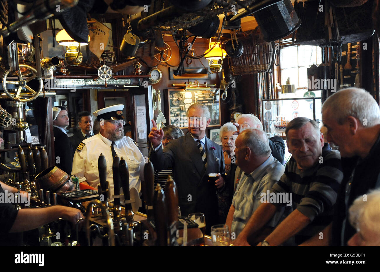 The Prince of Wales enjoys a drink with the locals in the Olde Ship Inn, Seahouses, Northumberland during the second day of his tour of the North-east. Stock Photo