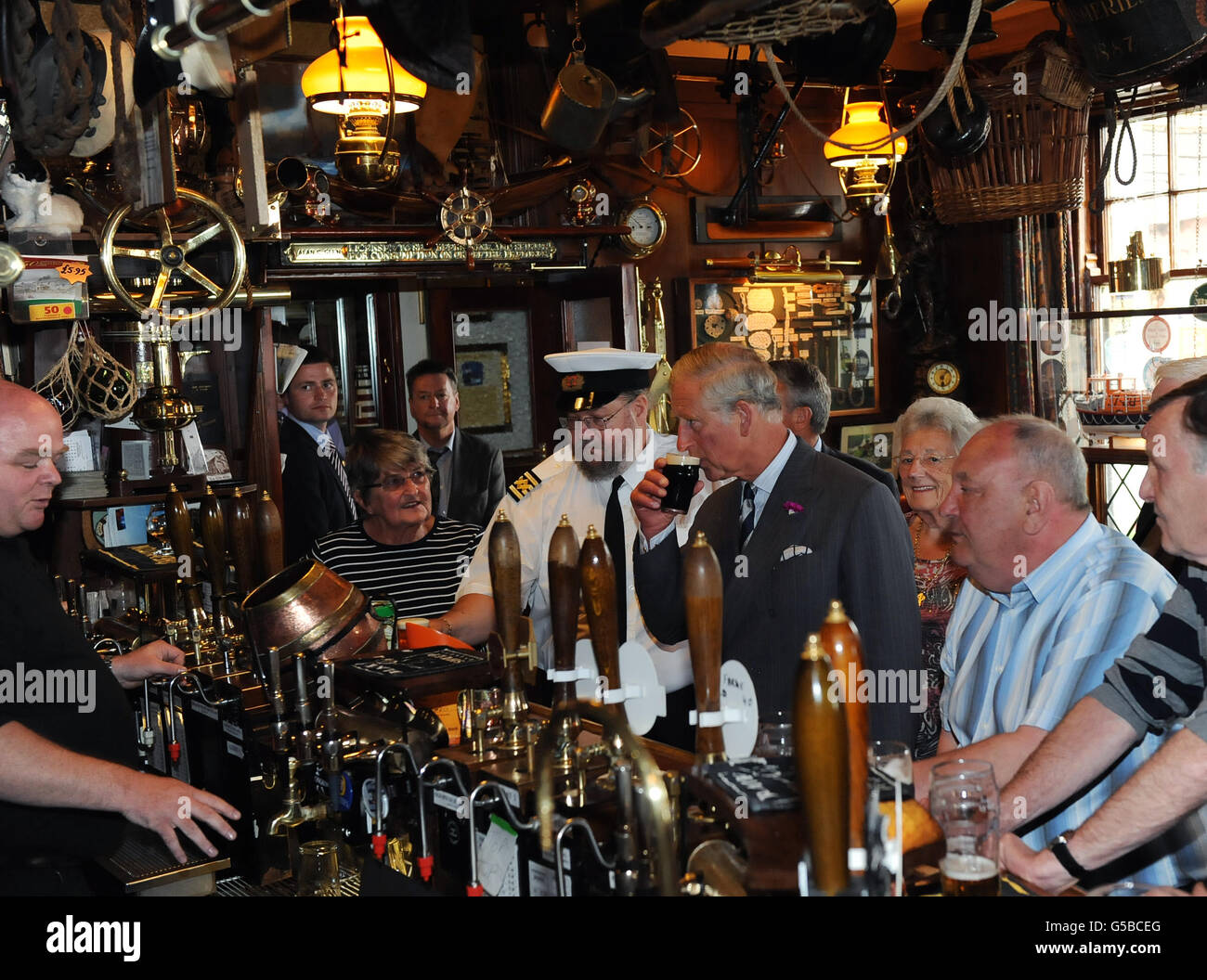 The Prince of Wales enjoys a drink with the locals in the Olde Ship Inn, Seahouses, Northumberland during the second day of his tour of the north east. Stock Photo