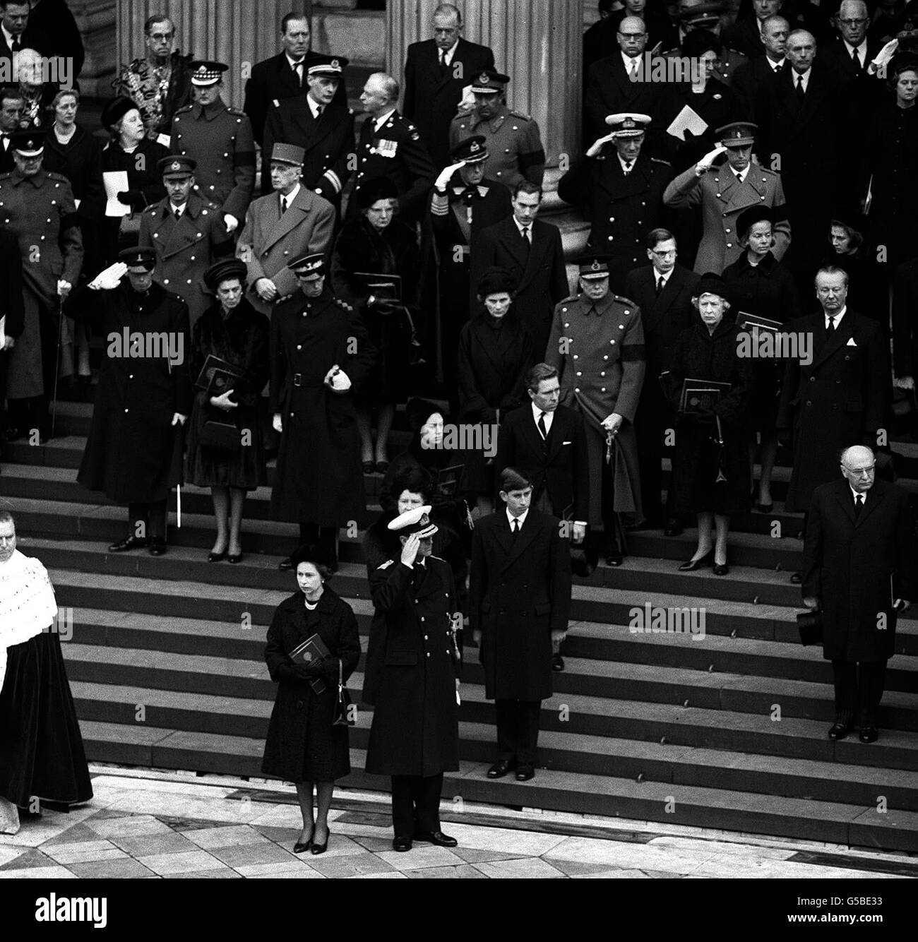 The Duke of Edinburgh and other distinguished mourners salute Sir Winston Churchill's coffin as it leaves St, Paul's Cathedral on the final stage of the State funeral. The Queen can be seen, foreground, beside the Duke. Stock Photo