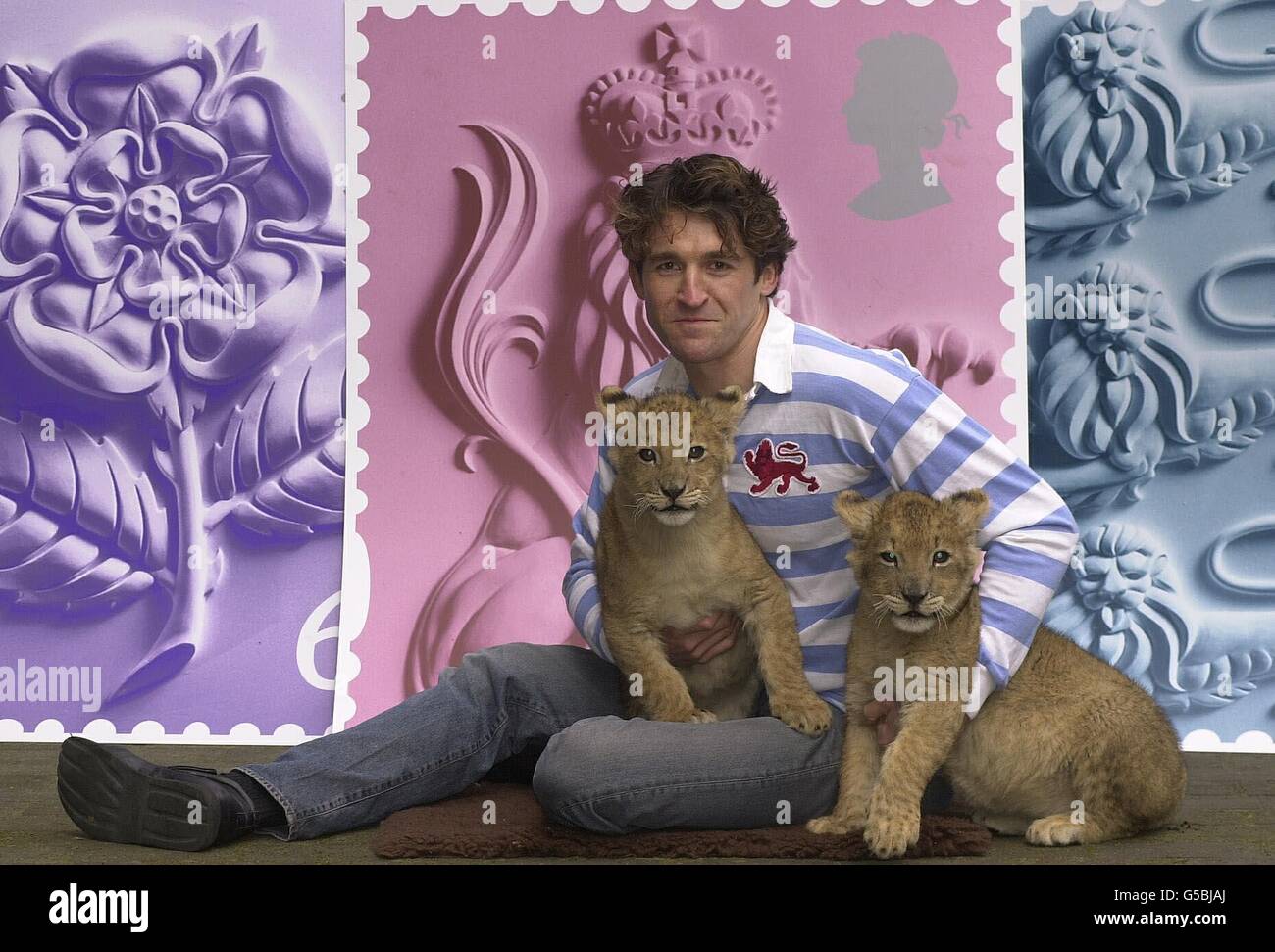 Actor Jonathan Cake, who stars in the forthcoming film Biggles, with Lion cubs Ben at the launch of the St. George's Day issue of new Royal Mail stamps at the headquarters of Consignia (formerly the Post Office), central London. *...The set, issued on 23 April 2001, feature the Crowned Lion of England, (1st class), the English Rose and the Three Lions of England (2nd class, not shown). Stock Photo