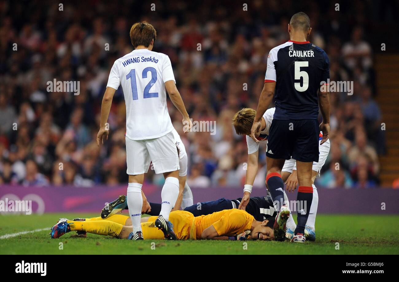 South Korea goalkeeper Sungryong Jung and Great Britain's Micah Richards lie injured on the floor after colliding during the Men's Quarter Final match at the Millennium Stadium, Cardiff, during day eight of the London 2012 Olympics. Stock Photo