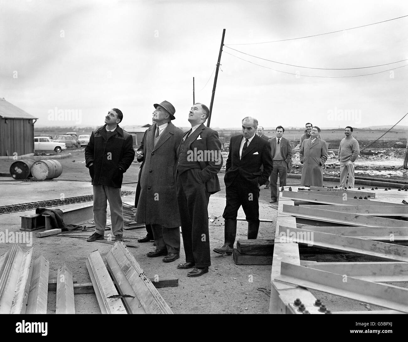 750,000 radio telescope under construction for the General Post Office at Goonhilly Down, near the Lizard. With him are P. Goodall (left, the resident engineer, and H.C Husband, designer of the telescope (he also designed the instrument at Jodrell Bank). The Goonhilly Down radio telescope is to be used in transatlantic television experiments. Stock Photo