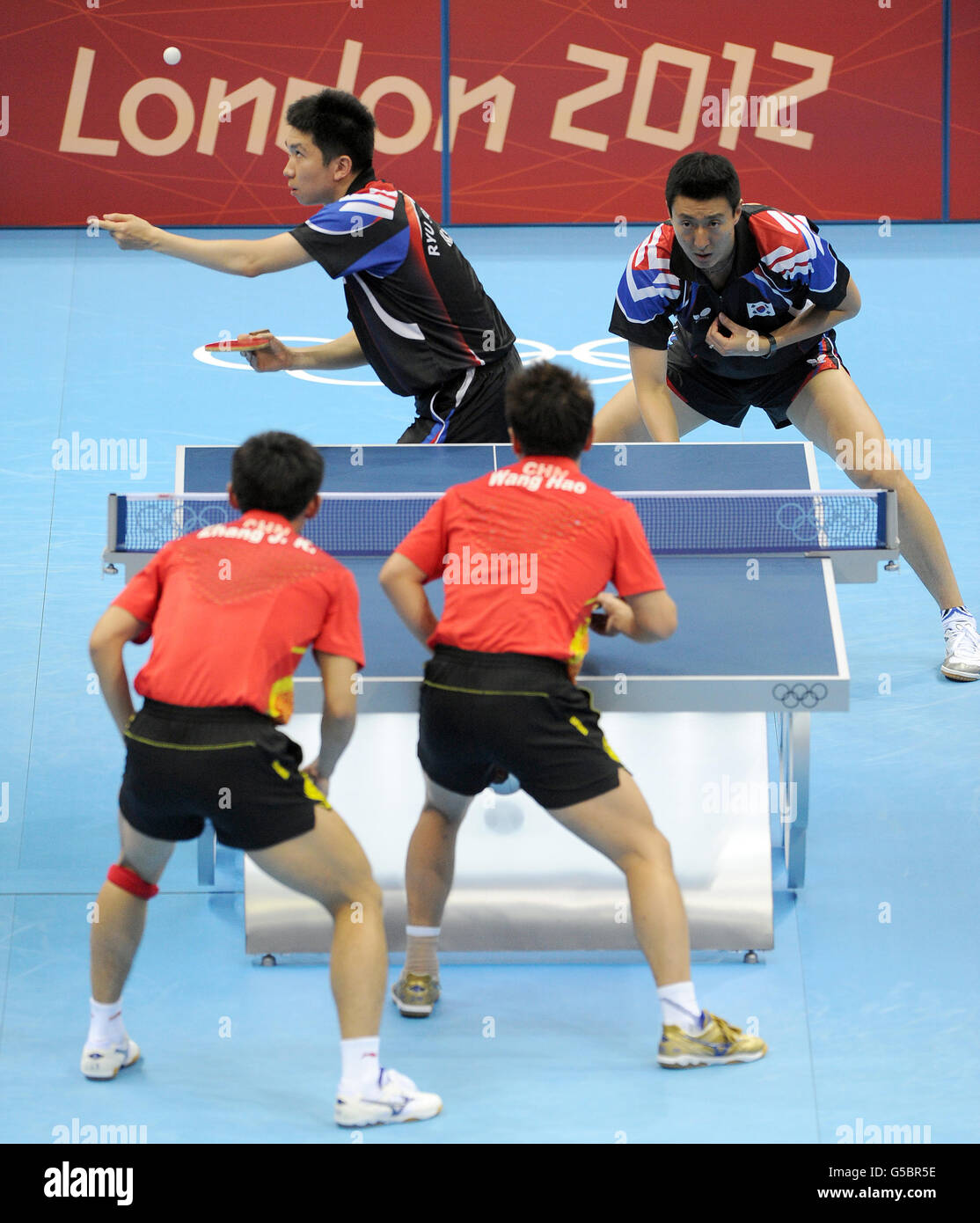 Republic of Korea's Ryu Seungmin (top left) and Oh Sangeun compete against China's Zhang Jike (bottom left) and Wang Hao during the Table Tennis team final at the ExCel centre, London Stock Photo