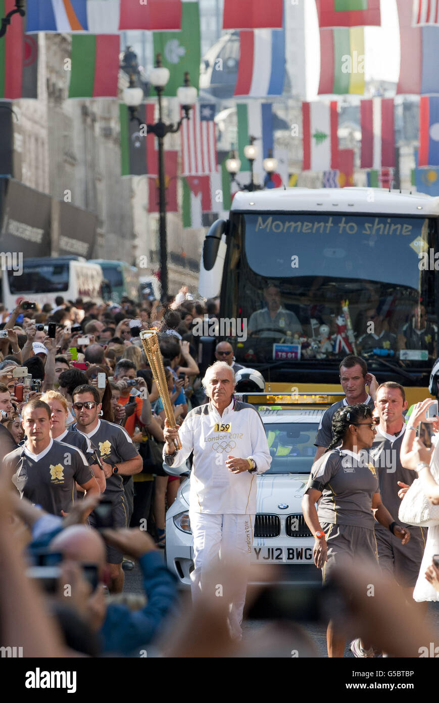 Torchbearer Mario Pescante carrying the Olympic Flame on the Torch Relay leg along Regent Street in London. Stock Photo