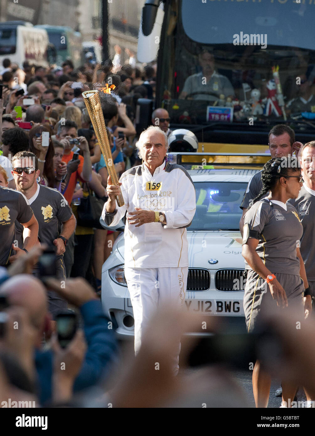 Torchbearer Mario Pescante carrying the Olympic Flame on the Torch Relay leg along Regent Street in London. Stock Photo