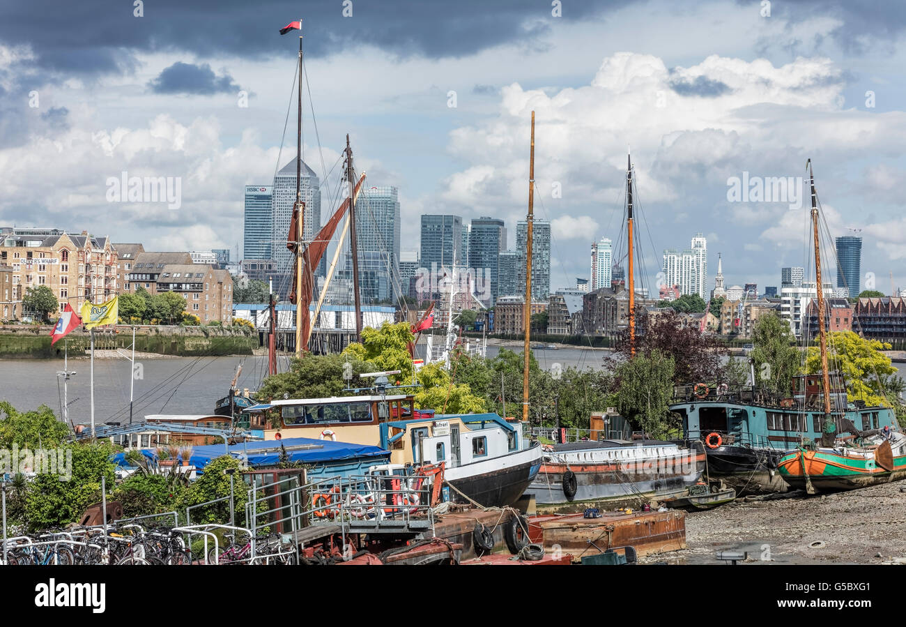 Barges and boats at Rotherhithe in London with Canary Wharf in the distance Stock Photo