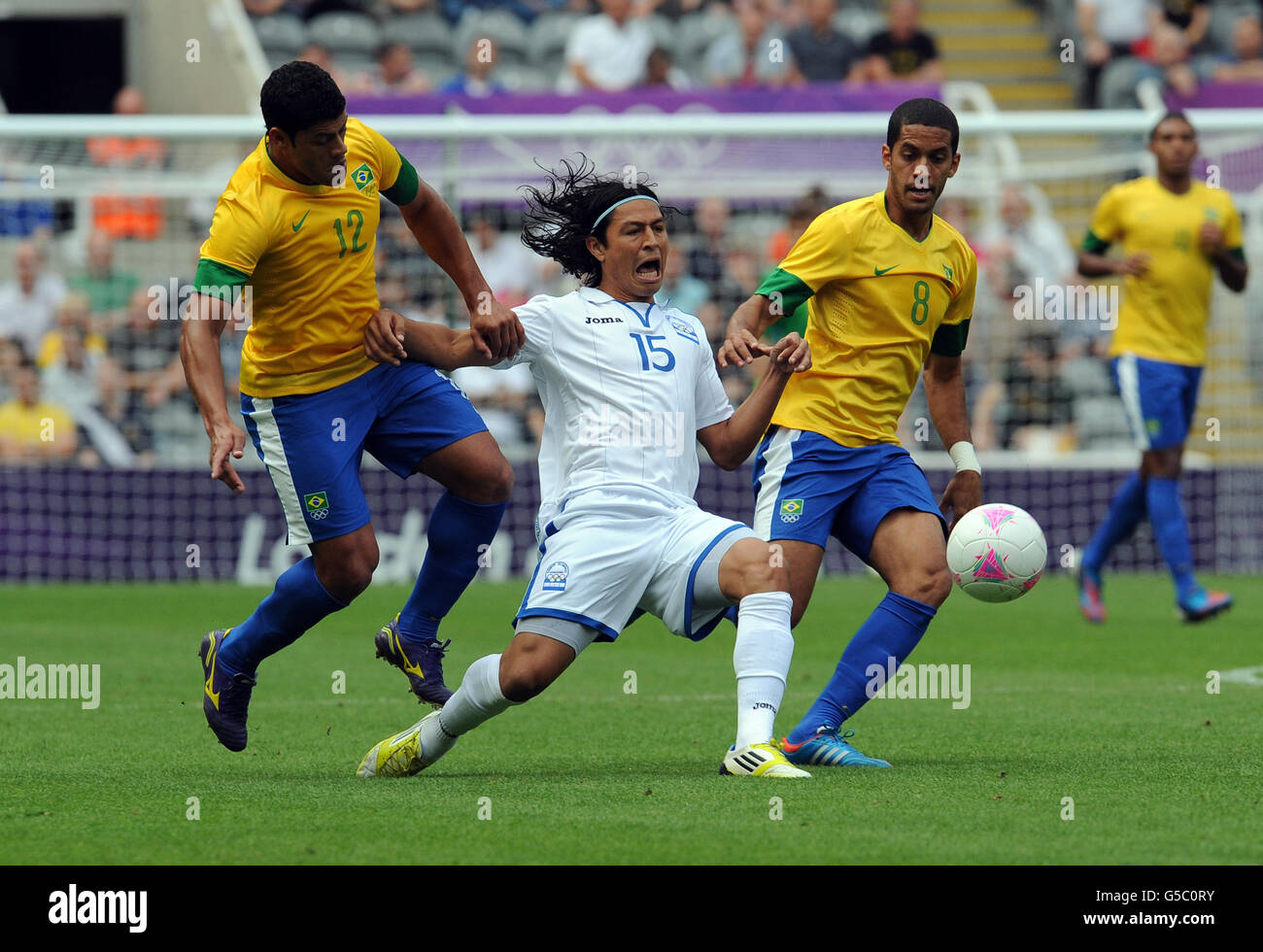 Honduras' Roger Espinoza reacts as he is tackled by Brazil's Hulk (left) and Romulo during the Men's Quarter final match at St James Park, Newcastle. Stock Photo