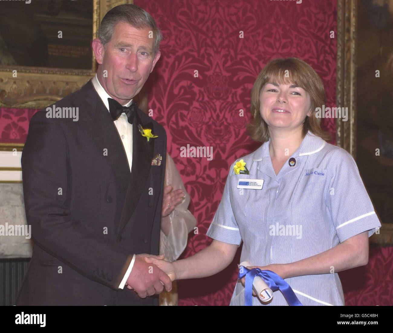 Prince Charles presents a Marie Curie nurse of the year award to Anne Coyle at St. James' Palace, London. Chosen from more than 4,000 Marie Curie nurses nationwide, who care for people with cancer, the four winners will act as ambassadors for their colleagues *... raising awareness and funds for the charity, which combined home and hospice nursing with research. Stock Photo