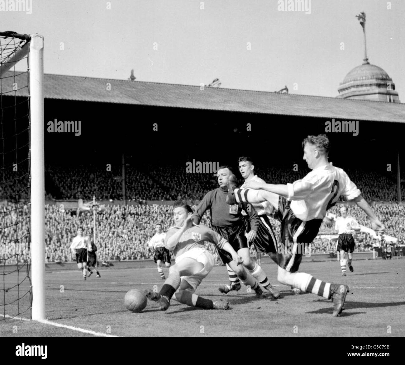 Blackpool footballer Stanley Mortenson (left) scores his team's second goal against Bolton Wanderers, during their 1953 FA Cup Final football match at Wembley Stadium, in London. Blackpool won 4-3. * L-R: goalkeeper S Hanson; centre-half M Barrass, and right-back J Ball (No 2). Stock Photo
