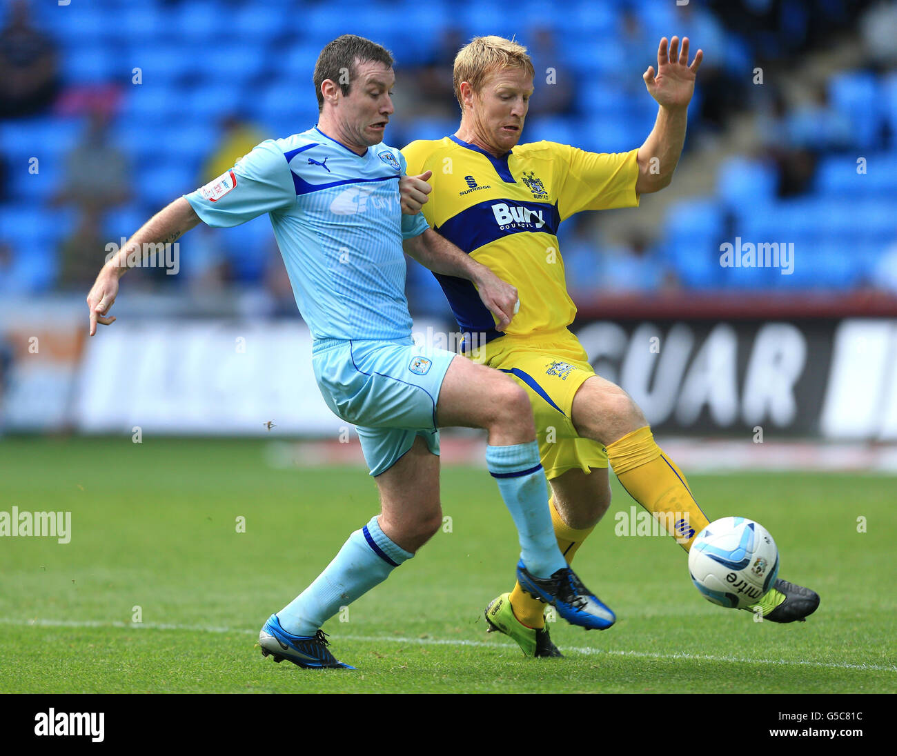 Coventry City's Stephen Elliott and Bury's Adam Lockwood (right) in action during the npower Football League One match at the Ricoh Arena, Coventry. Stock Photo