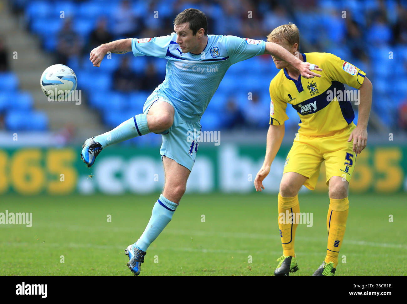 Coventry City's Stephen Elliott and Bury's Adam Lockwood (right) in action during the npower Football League One match at the Ricoh Arena, Coventry. Stock Photo