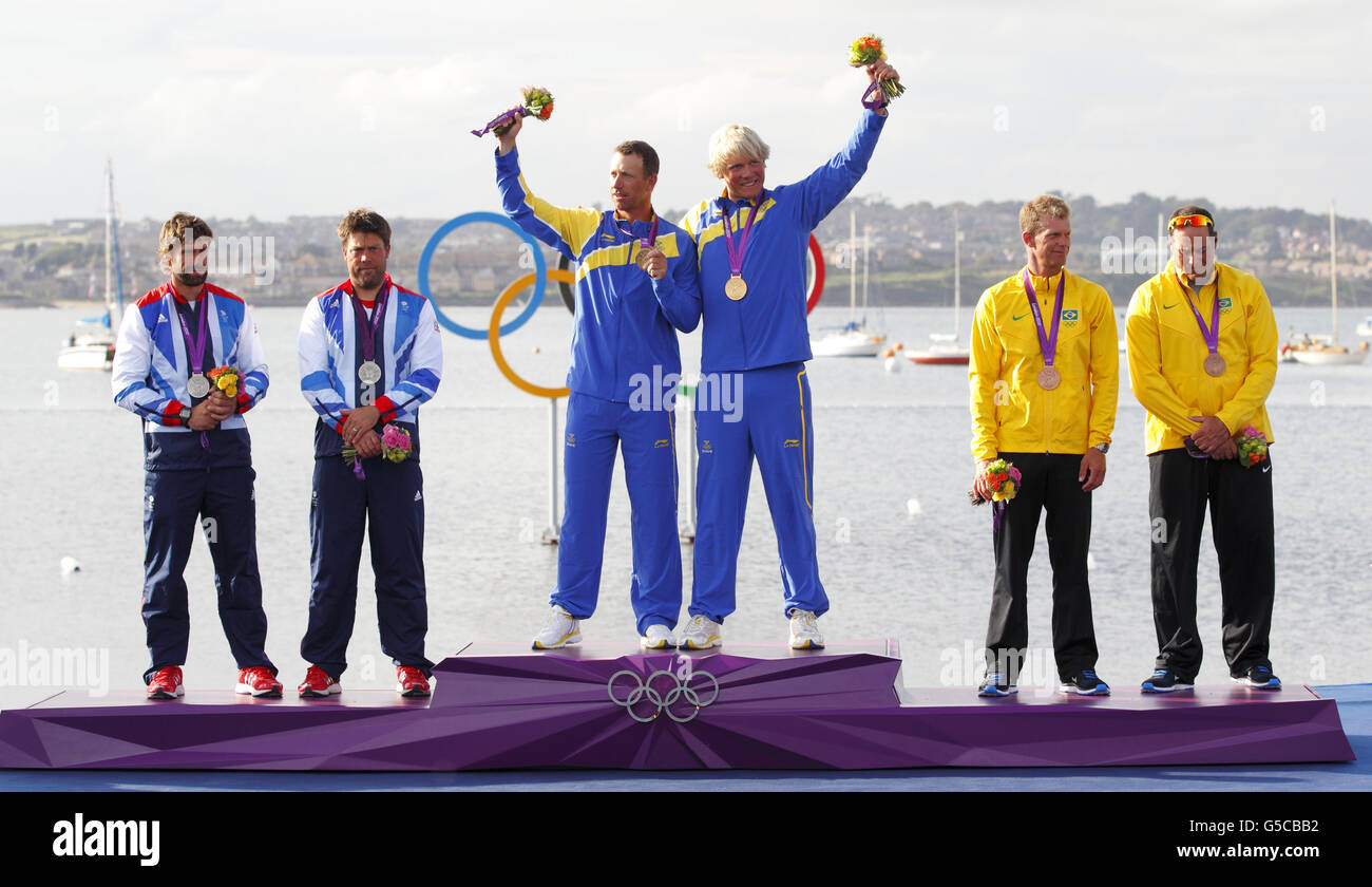 Sweden's Star class sailors Fredrik Loof and Max Salminen celebrate their Olympic gold medal flanked by Great Britain's Iain Percy and Andrew Simpson who won silver (left) and Brazil's Robert Scheidt and Bruno Prada who won bronze. Stock Photo