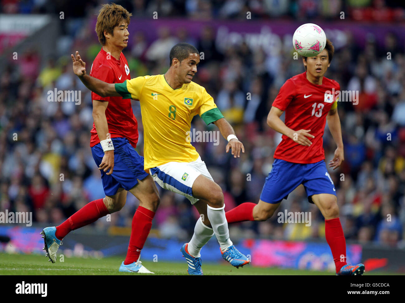 London Olympic Games - Day 11. Brazil's Romulo and South Korea's Sungyueng Ki against South Korea during the Olympic match at Old Trafford. Stock Photo